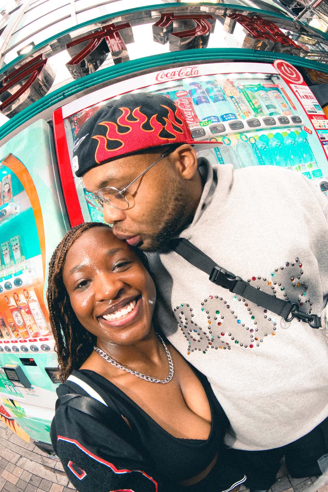 Couple smiling by a vending machine in Tokyo