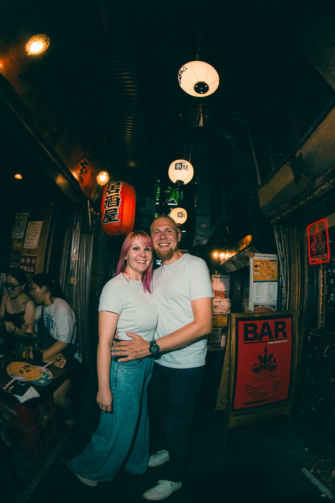 Couple in a lantern-lit Tokyo alley at night
