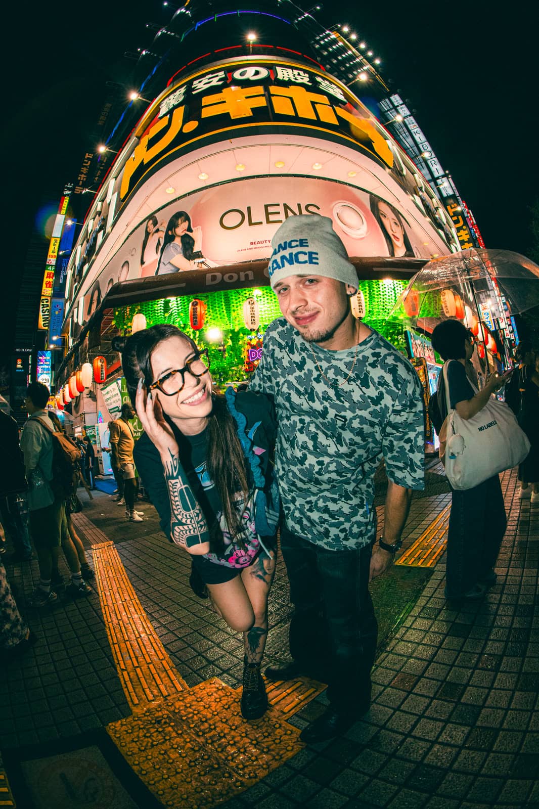 Couple on a neon-lit Tokyo shopping street at night