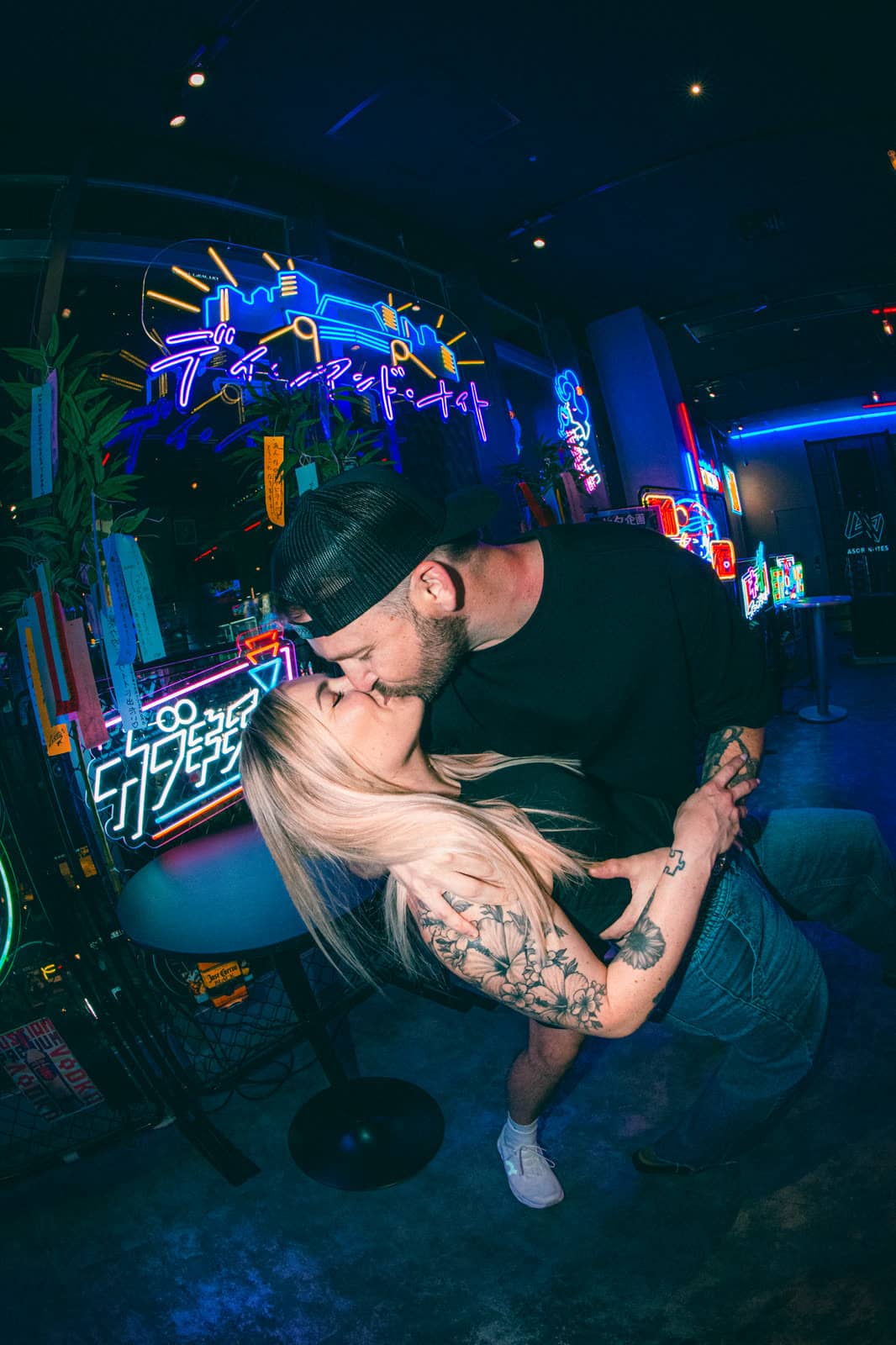 Couple kissing under neon lights in a Tokyo bar