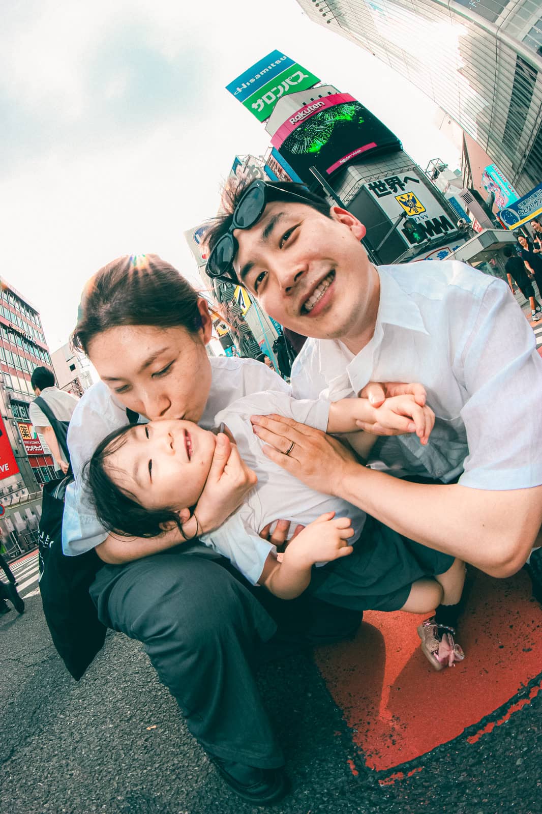 Parents hugging their toddler on a Tokyo street