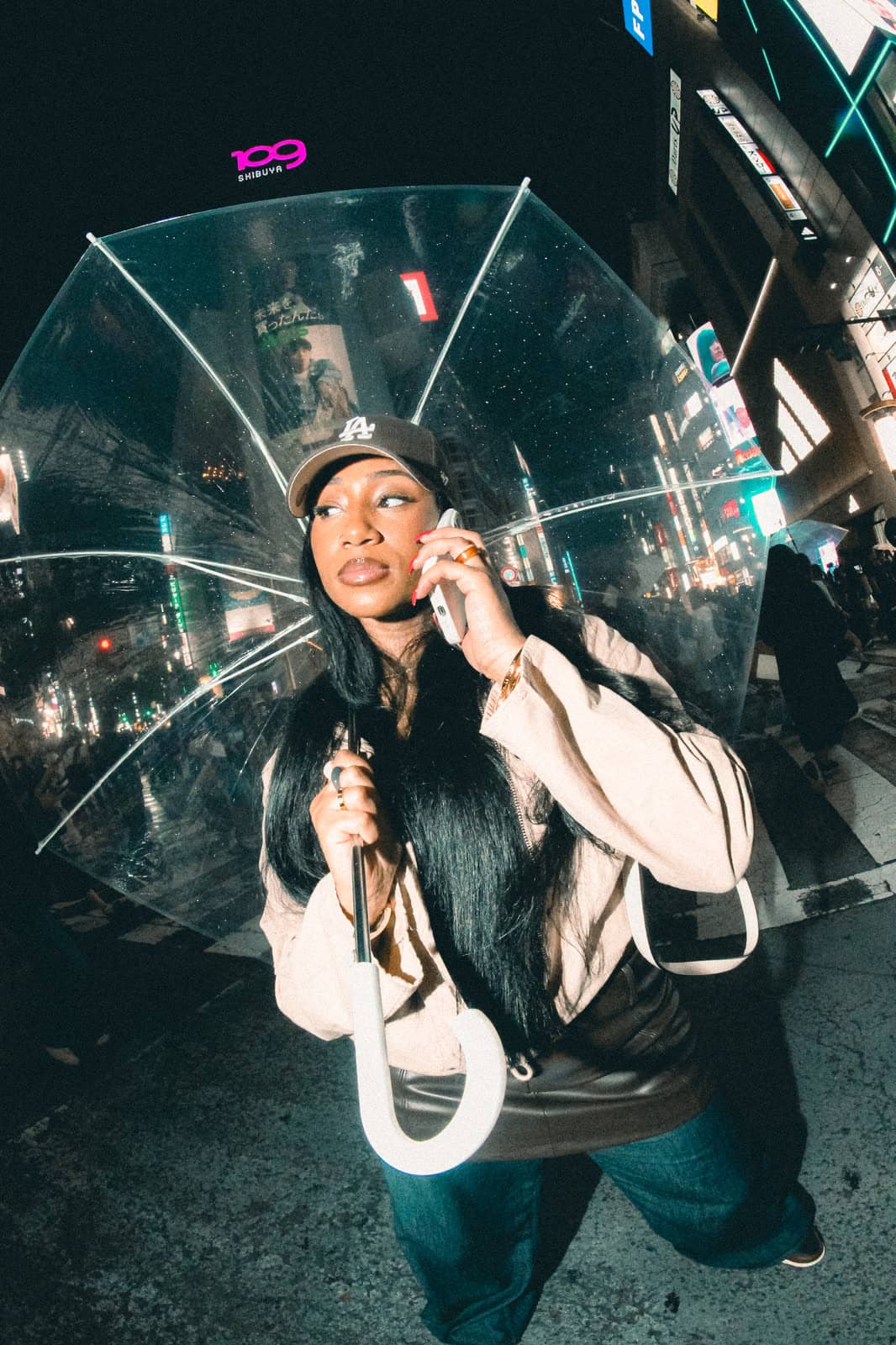 Woman with a clear umbrella on a Tokyo street at night