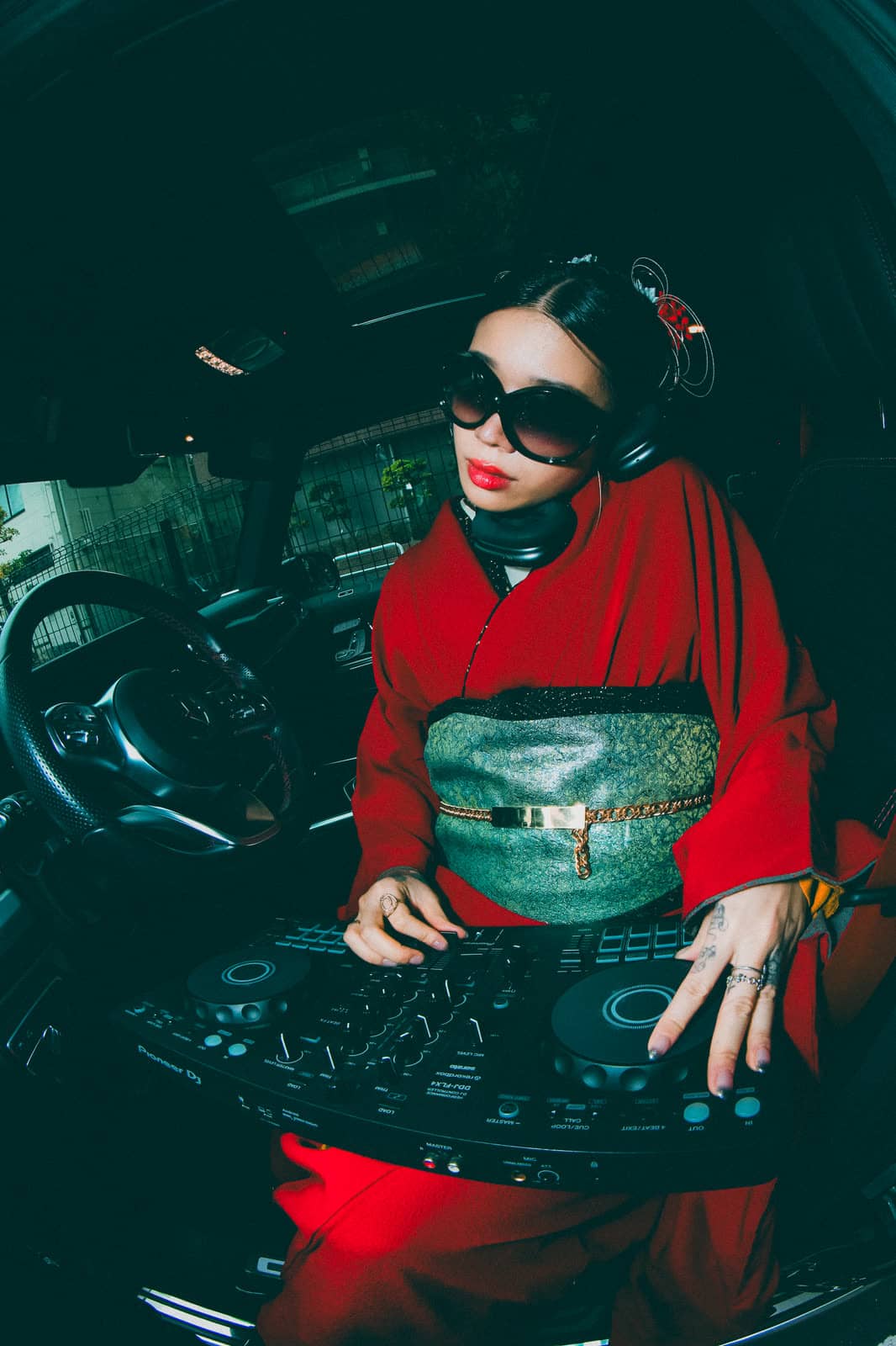 Woman in a red kimono playing a DJ set